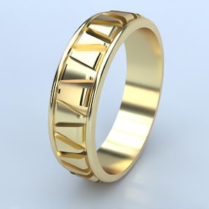 Puede incluir: Un anillo de banda de oro con un patrón geométrico alrededor de la banda.