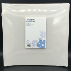Puede incluir: Un paquete blanco de papel Creative Memories Spargo 12x12 Multi-Page (100 pk). El paquete tiene un diseño de flores azules y el texto "Creative Memories Spargo 12x12 Multi-Page (100 pk) 100% Texture Paper 100 Page Protection" en la parte delantera.