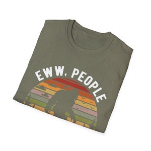 May include: A green t-shirt with a vintage-style graphic of a Bigfoot silhouette standing in front of a sunset with the text "EWW, PEOPLE".