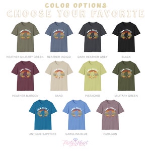 May include: A selection of t-shirts in various colors, featuring a retro-style graphic of a Bigfoot with the text "EWW. PEOPLE". The colors include heather military green, heather indigo, dark heather grey, black, heather maroon, sand, pistachio, military green, antique sapphire, carolina blue, and paragon.