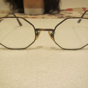 May include: A pair of octagon-shaped eyeglasses with a brown metal frame.