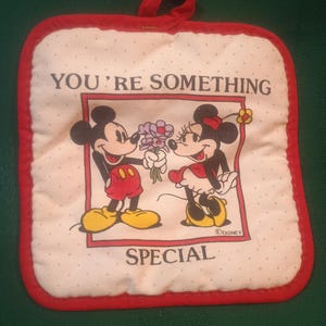 May include: Square white pot holder with a red border and a loop for hanging. Features a cartoon image of Mickey and Minnie Mouse with the text "YOU'RE SOMETHING SPECIAL".