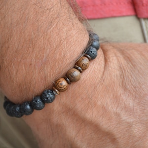 May include: A bracelet made of black lava rock and brown wood beads.