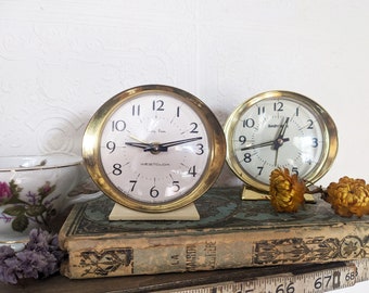 Réveil matin vintage blanc cassé et or Baby Ben par Westclox. Horloge mécanique pour étagère bureau 1950. Décor de chambre table de nuit