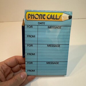 May include: A notepad for phone calls with a light blue background. The notepad has the words "PHONE CALLS" in a yellow banner with a pencil illustration. The notepad has spaces for the date, who the call is for, and the message.