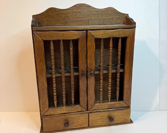 Vintage wooden spice cabinet with spindle doors. two small bottom drawers. Trinket shelf