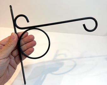 Vintage black metal wall-mounted hanging plant bracket. Hanging bracket hook