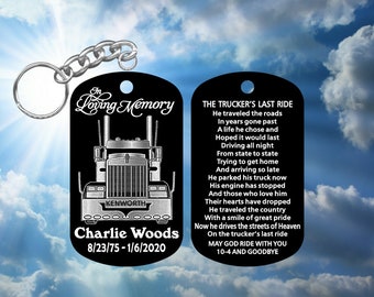 May include: Black and silver metal keychain with a truck driver memorial poem. The keychain features a silver truck with the words "In Loving Memory" and "Charlie Woods" with the dates "8/23/75 - 1/6/2020". The poem reads "The Trucker's Last Ride... 10-4 and Goodbye".