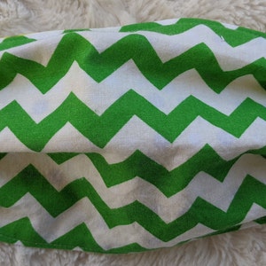 Puede incluir: Máscara facial con estampado de chevron verde y blanco con lazos elásticos para las orejas.