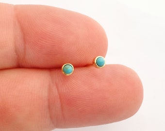 May include: A pair of small gold stud earrings with turquoise stones.
