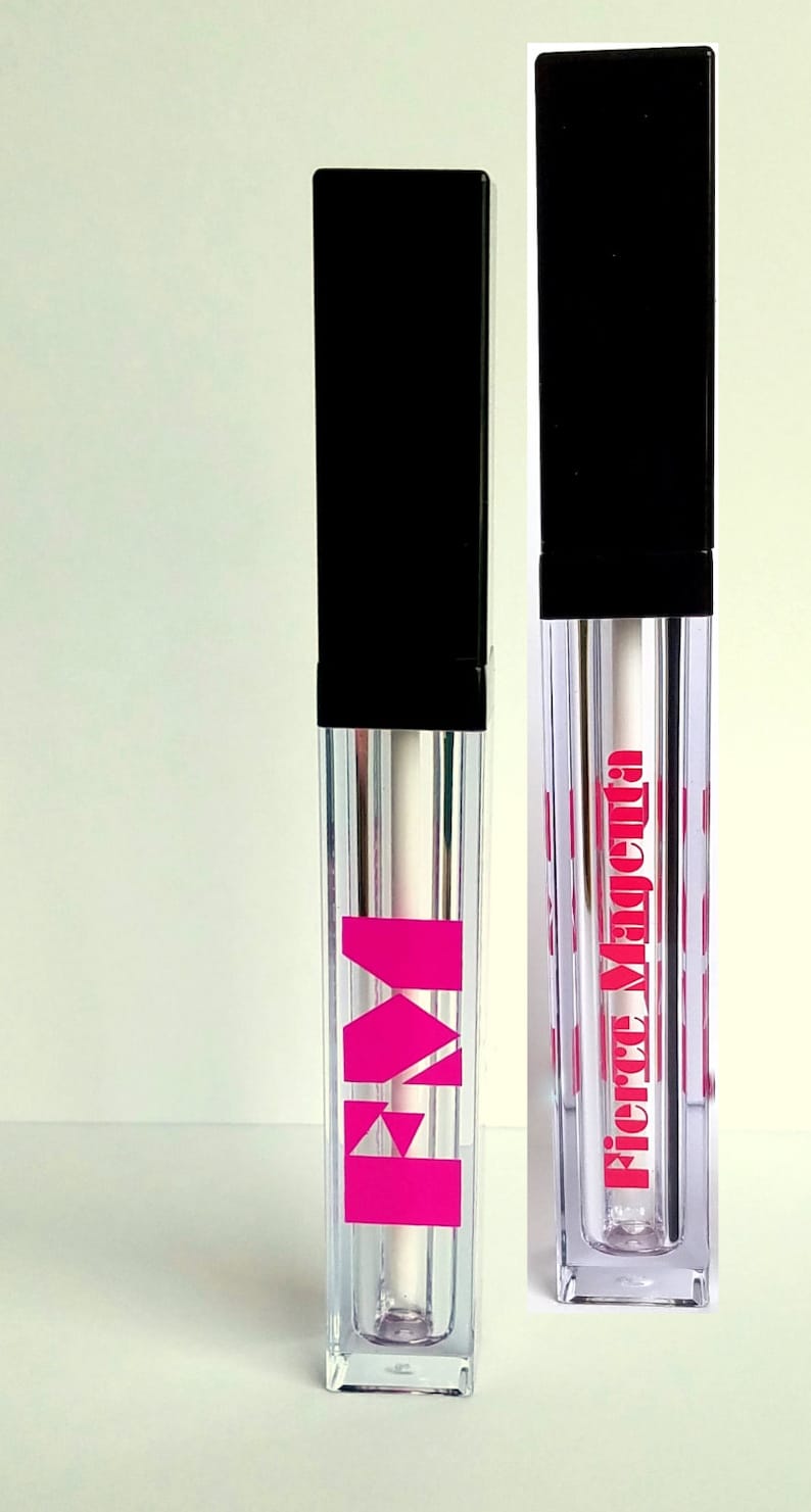 May include: Two clear lip gloss tubes with black caps. The tube on the left has a pink "M" logo. The tube on the right has the text "Fierce Magenta" in pink letters.