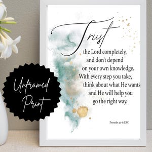 May include: A white framed print featuring the text Trust the Lord completely, and don't depend on your own knowledge. With every step you take, think about what He wants and he will help you go the right way. Proverbs 3:5-6 (ERV) with green watercolor and gold splatter accents.