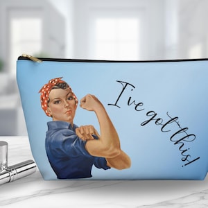 May include: Blue makeup bag with a vintage illustration of a woman with red polka dot headband and the text "I've got this!"
