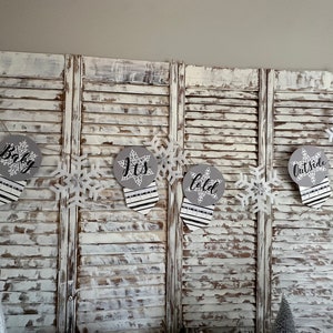 K&ouml;nnte beinhalten: Ein wei&szlig;-graues Babyparty-Banner mit Schneeflocken und dem Text "Baby, It's Cold Outside".