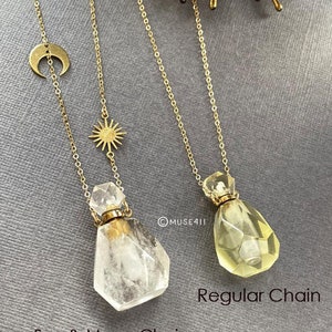 May include: Two gold necklaces with crystal bottle pendants. One necklace has a sun and moon charm, the other has a regular chain. The necklace with the sun and moon charm is labeled "Sun & Moon Chain" and the necklace with the regular chain is labeled "Regular Chain".