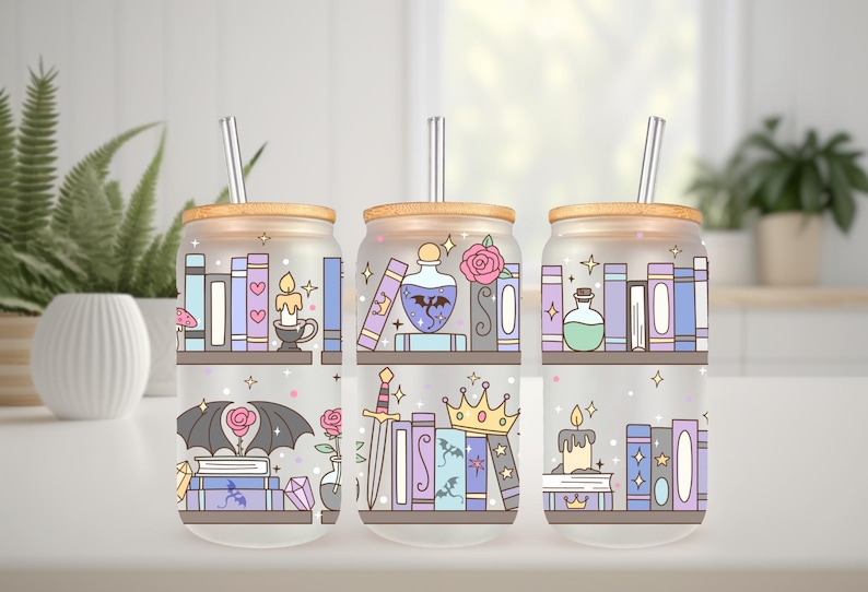 May include: Three glass tumblers with bamboo lids and silver straws. Each tumbler features a whimsical design of bookshelves, candles, potions, and fantasy elements in pastel colors. A decorative and functional item.