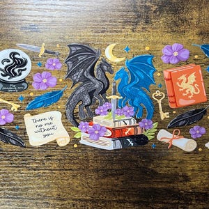 May include: A collection of fantasy-themed stickers featuring a black dragon and a blue dragon, books, swords, keys, flowers, a scroll, a candle, and a crystal ball. The text "My shadows are yours" and "There is no me without you" are included.