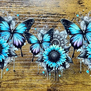May include: A decorative design featuring three butterflies with blue wings and black accents, paired with turquoise sunflowers. The butterflies and flowers are set against a backdrop of intricate black and white patterns and a rustic wood grain.