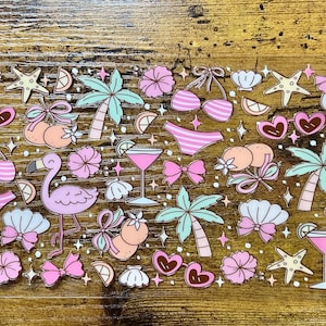 Könnte beinhalten: Eine Sammlung von Sommer-Themen-Aufklebern mit Flamingo, Bikini, Cocktail, Palmen, Muscheln und Schleifen. Die Aufkleber sind in Rosa, Orange und Türkis gehalten, mit einem Retro-Cartoon-Stil. Aufkleber auf einer Holzoberfläche.