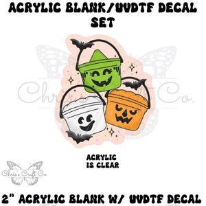 May include: A set of three Halloween-themed acrylic blanks with UVDTF decals. The image features a green, orange, and white bucket with jack-o'-lantern and ghost faces. The text reads "ACRYLIC BLANK/UUDTF DECAL SET" and "ACRYLIC IS CLEAR". The acrylic blanks are 2 inches.