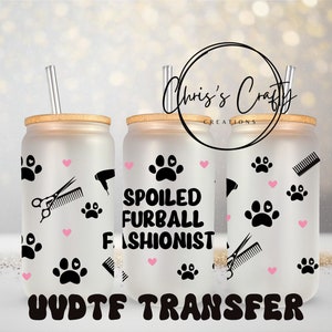 May include: Three frosted glass tumblers with bamboo lids and straws. The tumblers have a black paw print design with pink hearts and the text "Spoiled Furball Fashionist". The text "UV/DT/F Transfer" is printed below the tumblers.