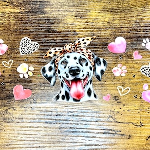 Op de afbeelding: Een zwart-witte Dalmatiër met een roze tong die uitsteekt, draagt ​​een bruin en zwart bandana. De hond is omringd door roze poot afdrukken en harten, sommige met een luipaardprint.