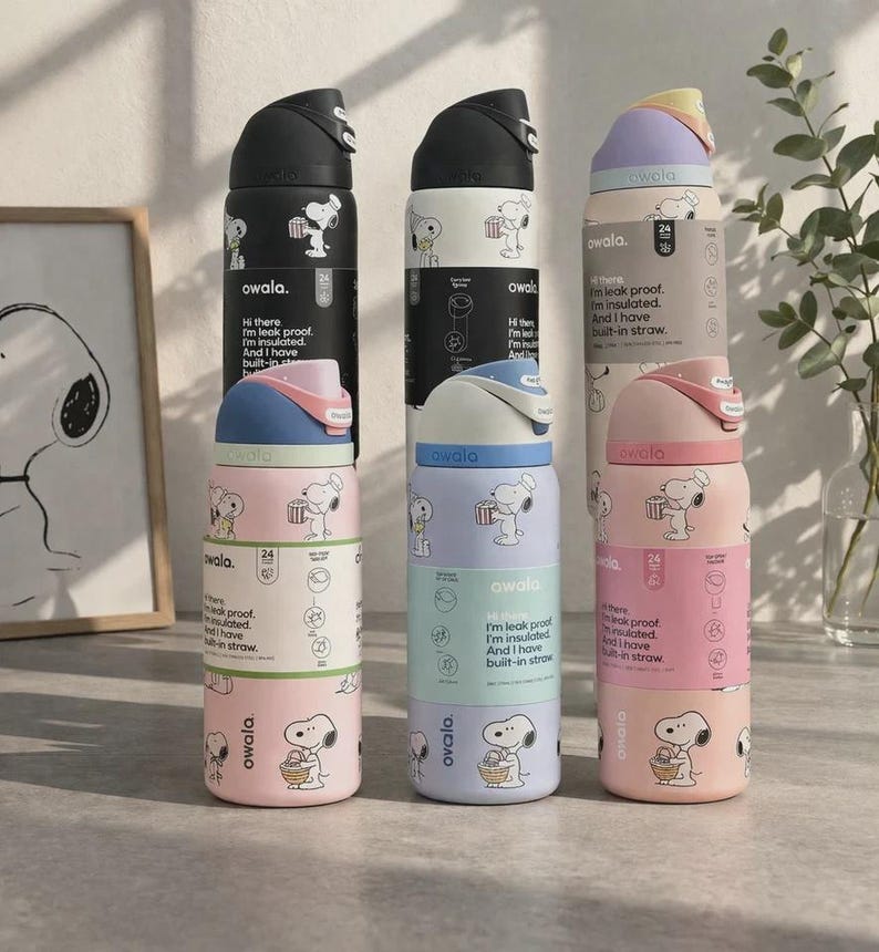 Op de afbeelding: Verschillende ge&iuml;soleerde waterflessen in pastelkleuren, met een cartoon hond ontwerp. Elke fles heeft een deksel en een rietje in een andere kleur. De flessen zijn gestapeld en tonen de merknaam en productkenmerken.