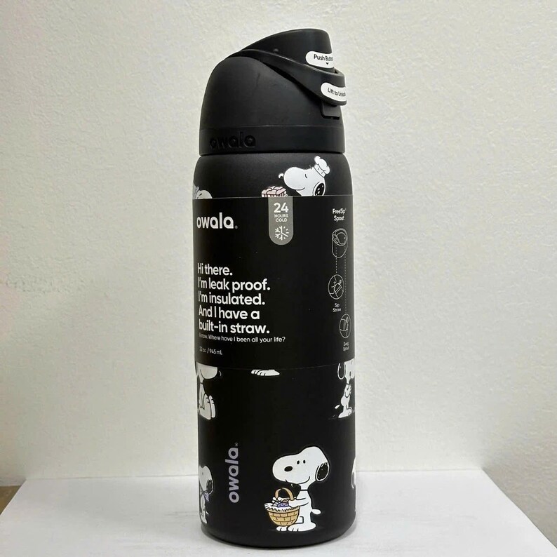 May include: Black Owala water bottle featuring Snoopy illustrations. The bottle has a black lid with a push button and a built-in straw. The bottle is insulated and leak-proof. The bottle is 745 ml.