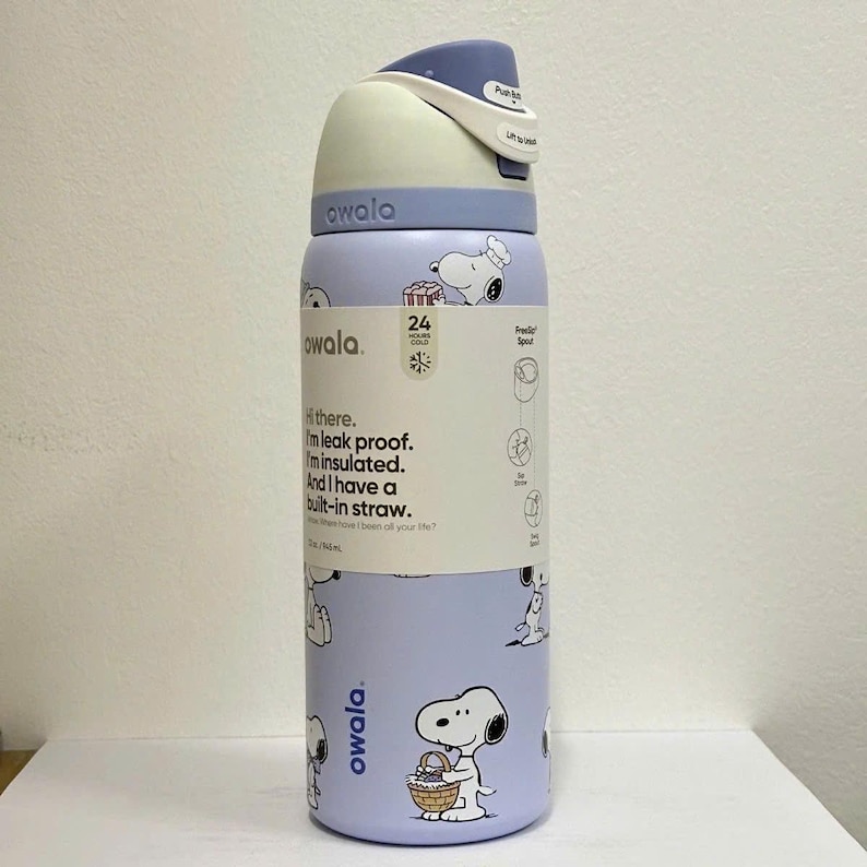 May include: A light purple Owala water bottle with a Snoopy pattern. The bottle has a white and blue lid with a push-button opening. Text on the bottle reads "I'm leak proof. I'm insulated. And I have a built-in straw."