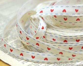 30 yard roll of natural muslin printed ribbon with hearts and light blue stitching