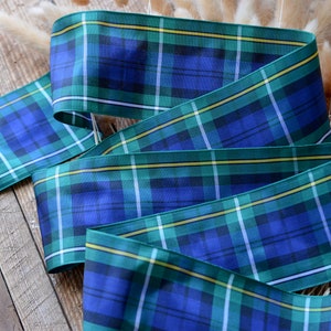 May include: Blue, green, and yellow plaid ribbon with a satin finish. The ribbon is folded in a decorative way.