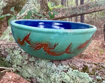 The dolphins of the Outer Banks frolic with a mermaid around the outside of this sweet bowl