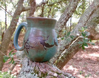 A mermaid and 3 peace turtles swim and play across this  coffee mug