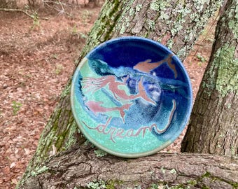 The dolphins of the Outer Banks frolic with a mermaid on this sweet little DREAM dish