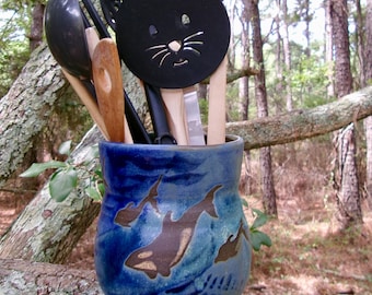 OBX dolphins and a few orcas frolic around the outside wall of  this  large kitchen utensil crock