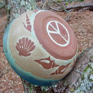 Sea shells have washed up onto the shore on this medium sized serving bowl