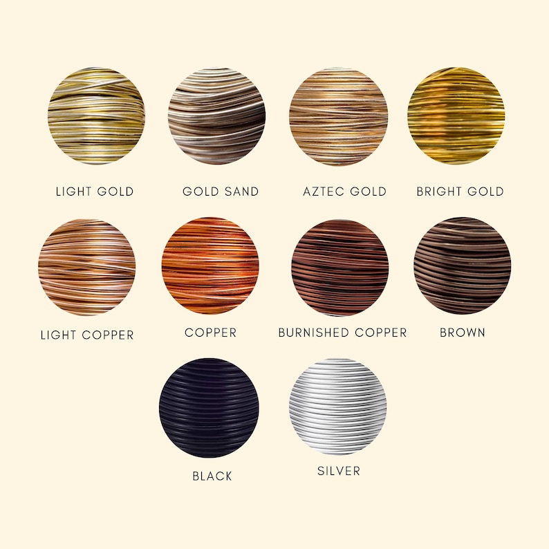 Op de afbeelding: Een verzameling draadspoelen in diverse kleuren, waaronder goud, koper en zilver, met een zwarte spoel. De kleuren zijn: licht goud, goud zand, Azteeks goud, helder goud, licht koper, koper, gebrand koper, bruin, zwart en zilver.