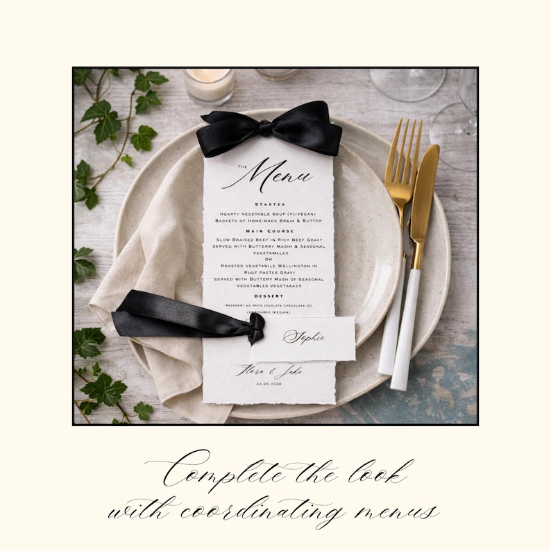 May include: A vertical menu card with deckled edges, featuring black text and a black satin ribbon bow at the top. A smaller name card with the name Sophie is attached with a black ribbon. The menu is placed on a ceramic plate with a beige napkin.