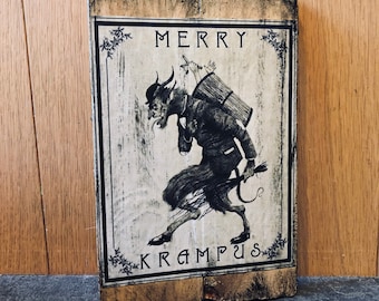 Puede incluir: Un letrero de madera con una ilustración en blanco y negro de Krampus, una criatura mítica del folclore germánico, que lleva un saco a la espalda. El letrero dice "Merry Krampus".