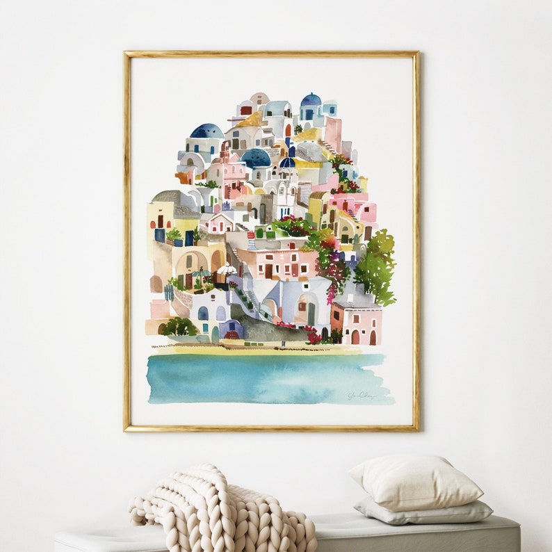 Peut inclure: Peinture &agrave; l'aquarelle d'un village color&eacute; avec des b&acirc;timents blancs, des accents bleus et une &eacute;tendue d'eau turquoise au premier plan. Le village est construit &agrave; flanc de colline avec une vari&eacute;t&eacute; de plantes et de fleurs.