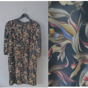 80er Jahre Herbst Kleid. Romantisches Kleid aus locker sitzendem Jersey mit Schulterpolstern, Blätter & Blumen Muster. In einem sehr guten Vintage Zustand.