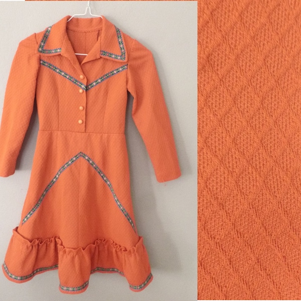 Robe hippie fille des années 70, 9-10 ans. Robe longue orange en polyester épais, détails floraux multicolores. Dans un très bon état vintage.