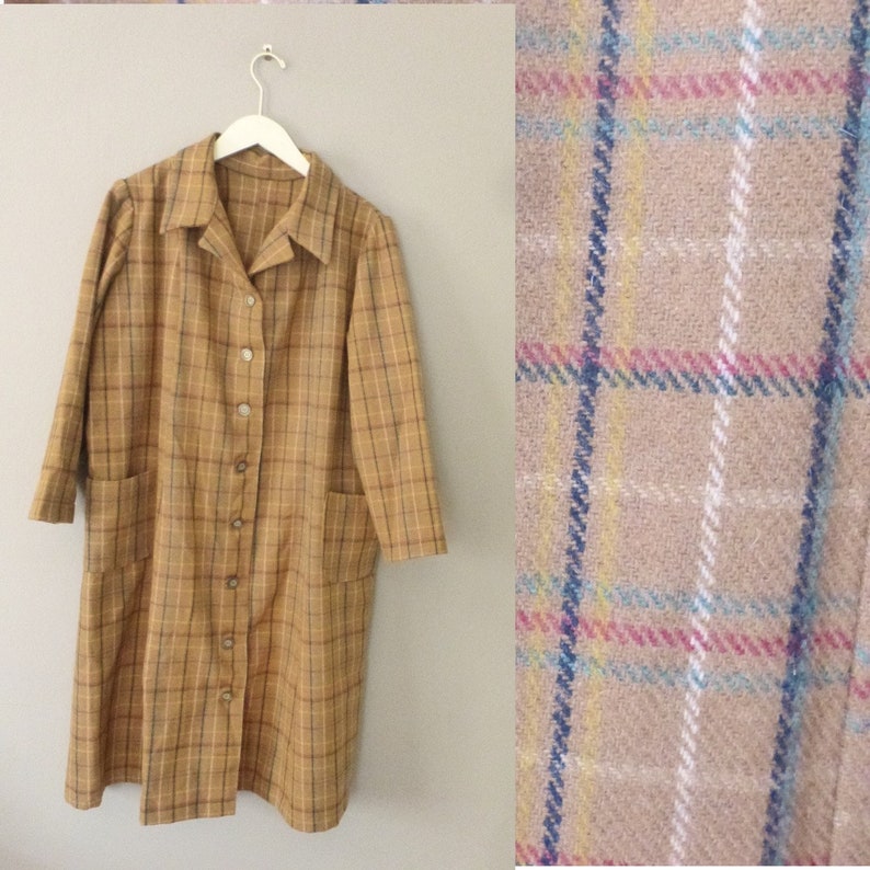 May include: A long, brown plaid coat with a button-up front and two pockets. The coat has a collar and long sleeves.