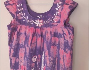 Robe batik des années 70. Taille XL. Robe violette sans manches en coton avec des motifs floraux roses et blancs faits main. Dans un très bon état vintage.