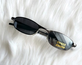 May include: Silver-toned sunglasses with black lenses. The sunglasses have a UV400 label on the right lens, indicating 100% UV block.