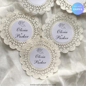 May include: Off-white lace doilies with a circular center featuring the names "Olivia + Parker" and a small cupid illustration. The doilies are arranged on a white fabric surface. The Etsy shop name "PAPERANDFONDANT.ETSY.COM" is visible.