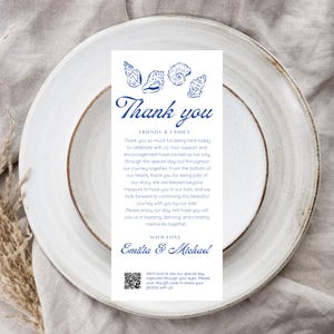 Peut inclure: Une carte de remerciement de mariage bleu marine avec des illustrations de coquillages. La carte présente les mots "Thank you" en écriture élégante, ainsi qu'un message de gratitude et les noms "Emilia & Michael". Un code QR est inclus.