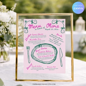 Może przedstawiać: Różowa karta menu w złotej ramie, z ręcznie napisanym menu na specjalną okazję. Menu zawiera przystawki, dania główne, desery i napoje. Tekst zawiera imię "Olivia" i datę "22 sierpnia 202x".
