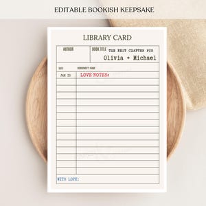 May include: A rectangular library card with black text reading LIBRARY CARD, AUTHOR, BOOK TITLE, THE NEXT CHAPTER FOR OLIVIA + MICHAEL, DATE, BORROWER'S NAME, JAN 10, LOVE NOTES in red, and WITH LOVE in blue, featuring horizontal lines for writing.