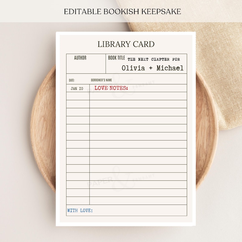 May include: A rectangular library card with black text reading LIBRARY CARD, AUTHOR, BOOK TITLE, THE NEXT CHAPTER FOR OLIVIA + MICHAEL, DATE, BORROWER'S NAME, JAN 10, LOVE NOTES in red, and WITH LOVE in blue, featuring horizontal lines for writing.